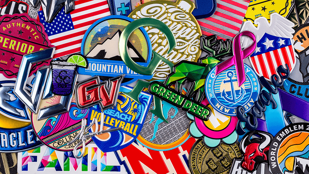 An industrial embroidery machine creating multiple chenille patches with the text “World Emblem” and a white star design on black fabric. The patches are arranged in rows, highlighting the automated production process for high-quality custom emblems and apparel branding.