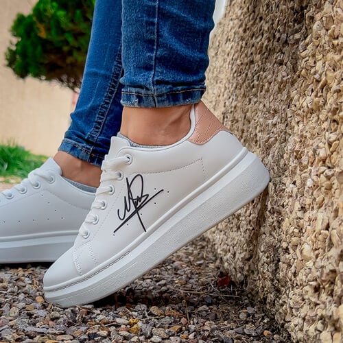 woman wearing white casual tennis shoes with a silver FlexStyle Signature